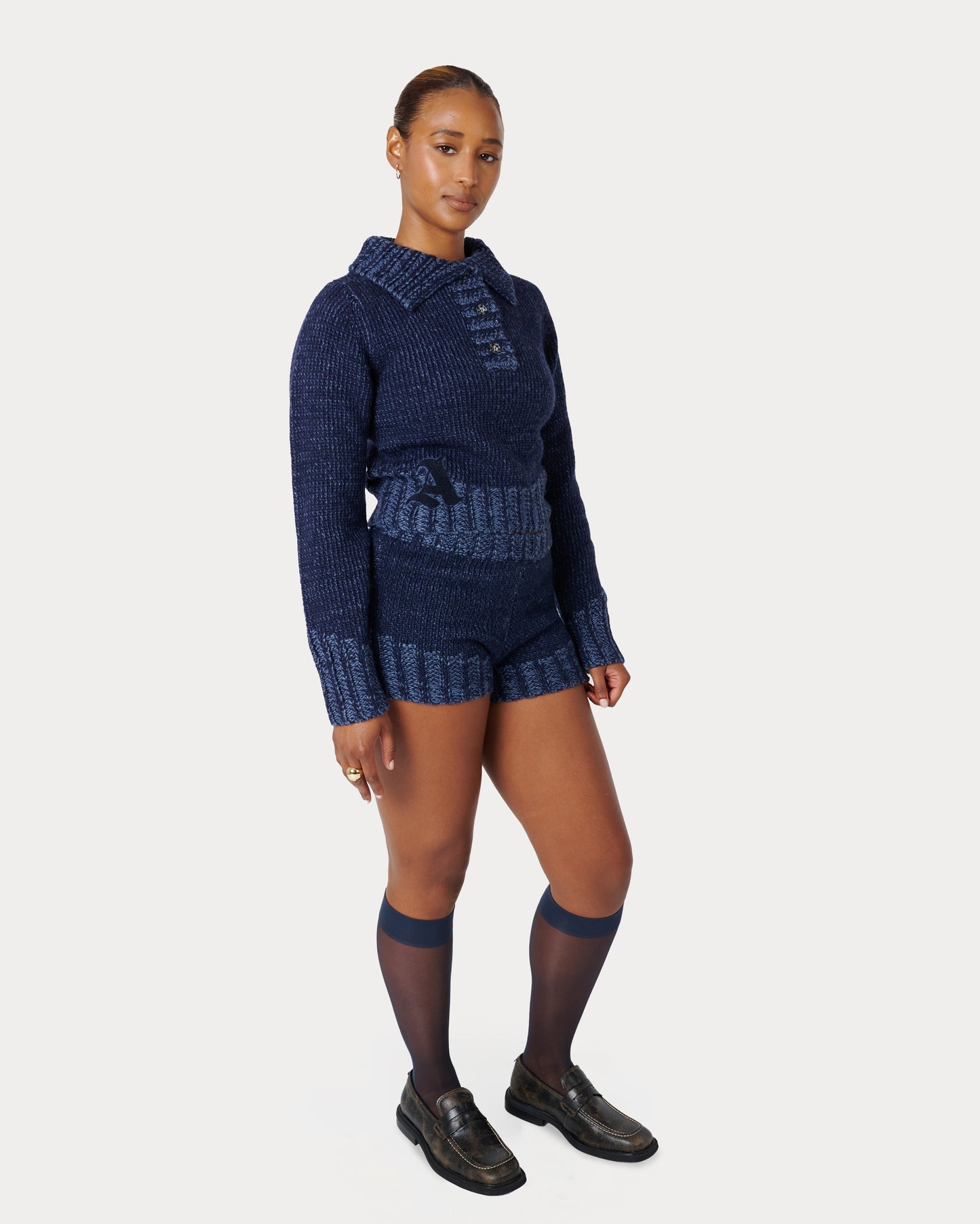 Female Model is wearing size Medium in Zaya Knit Mini Shorts by Aseye Studio in Dark Blue