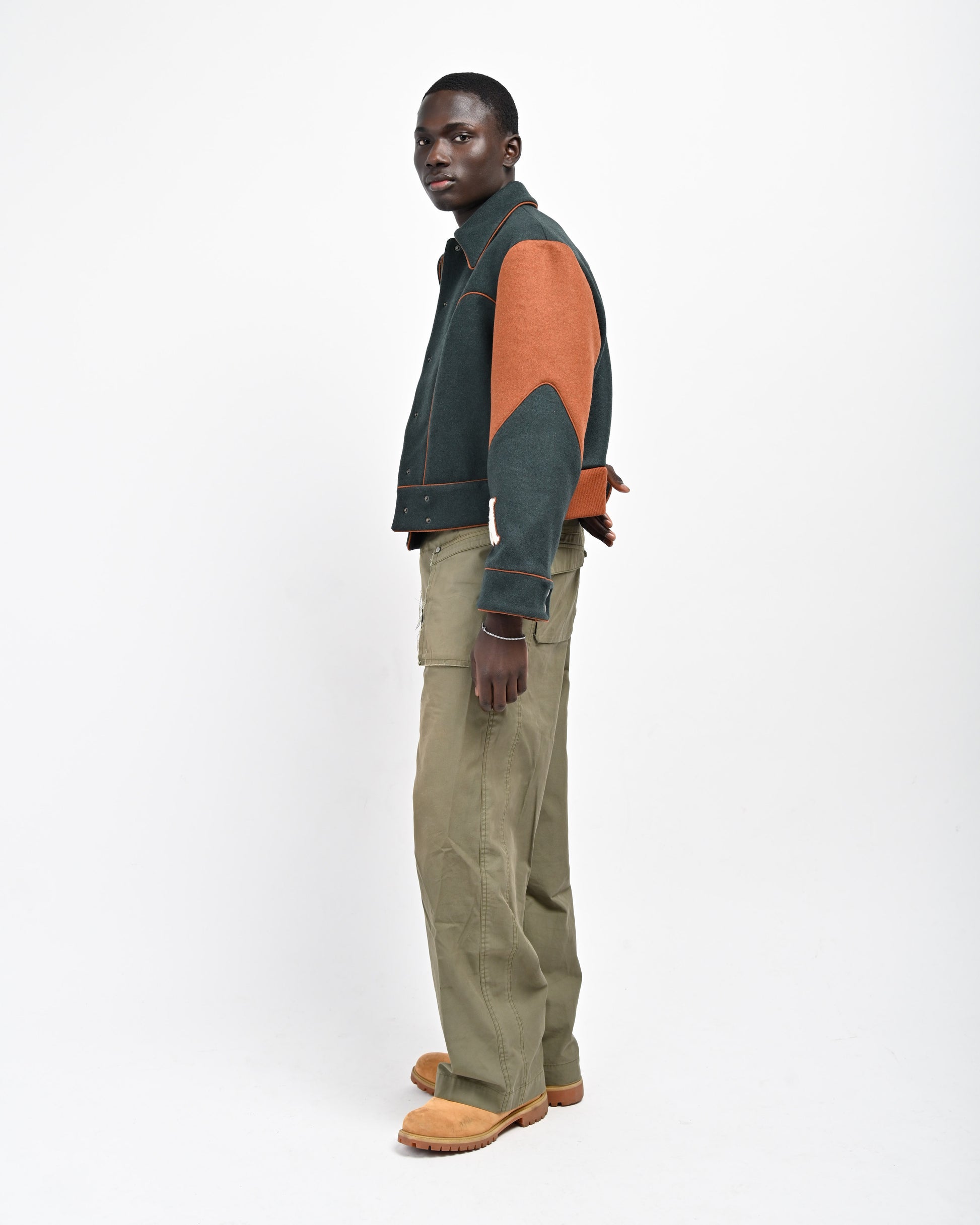 Side View of Model wearing Green Rue Varsity Jacket by Aseye Studio